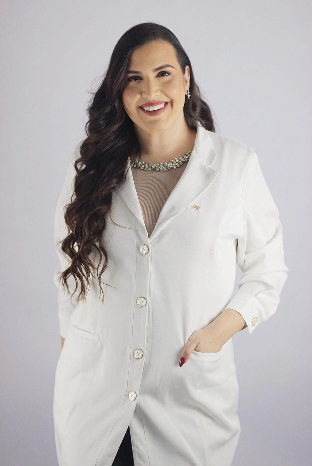 Dra. Alline Fontes, médica mastologista, de jaleco branco